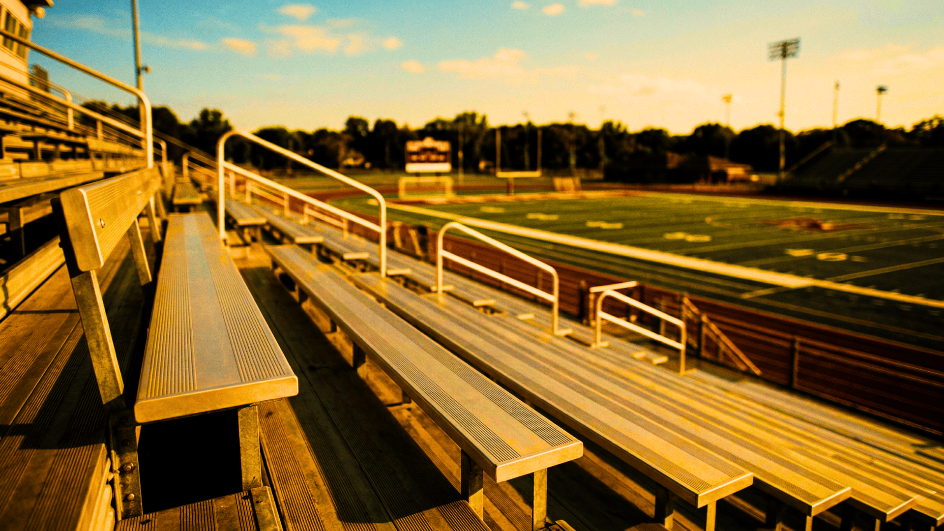 Bleachers on a sports field during sunset